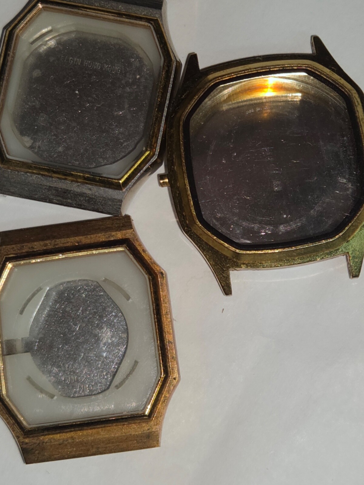 Four (4) men’s watch cases. 1980’s. For quartz movements. One has rotating bezel