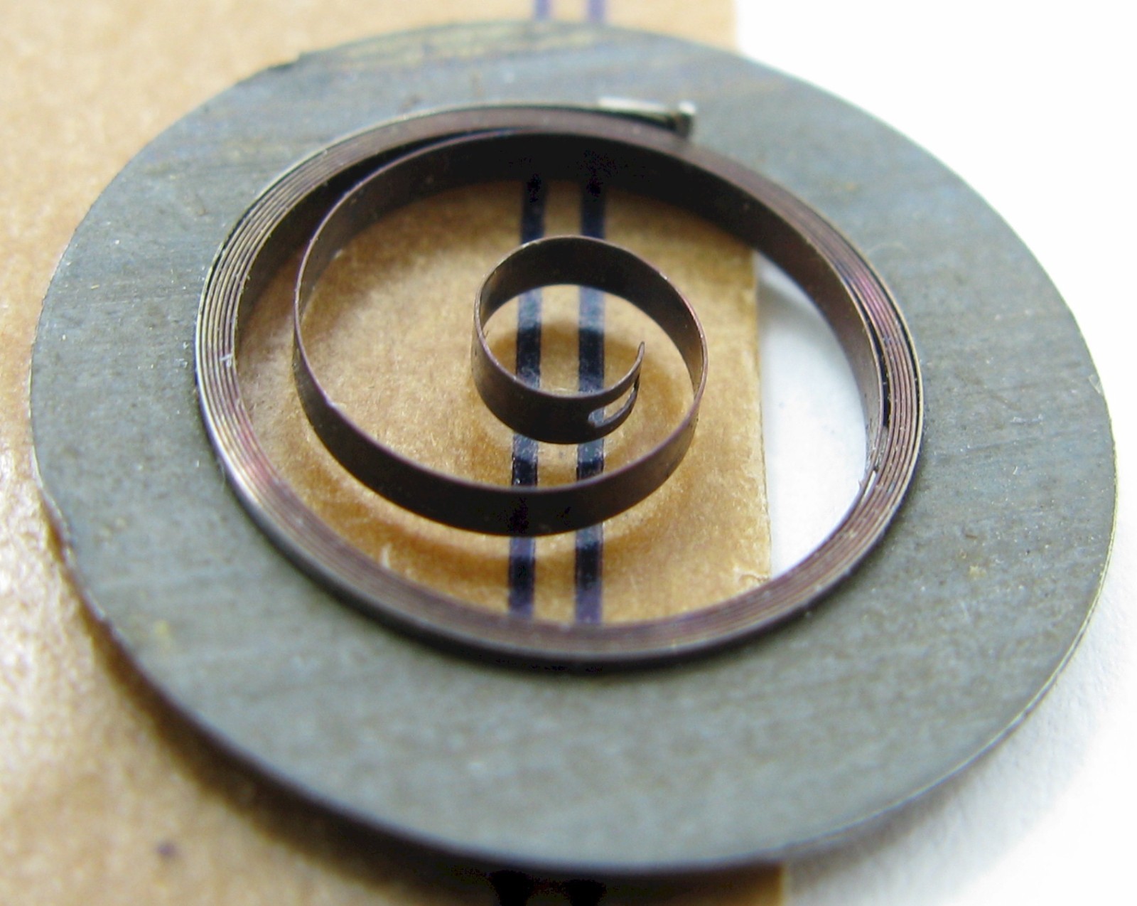 Hamilton 18/0s 2721 17 j. Watch part: T end Mainspring x1 brown alloy