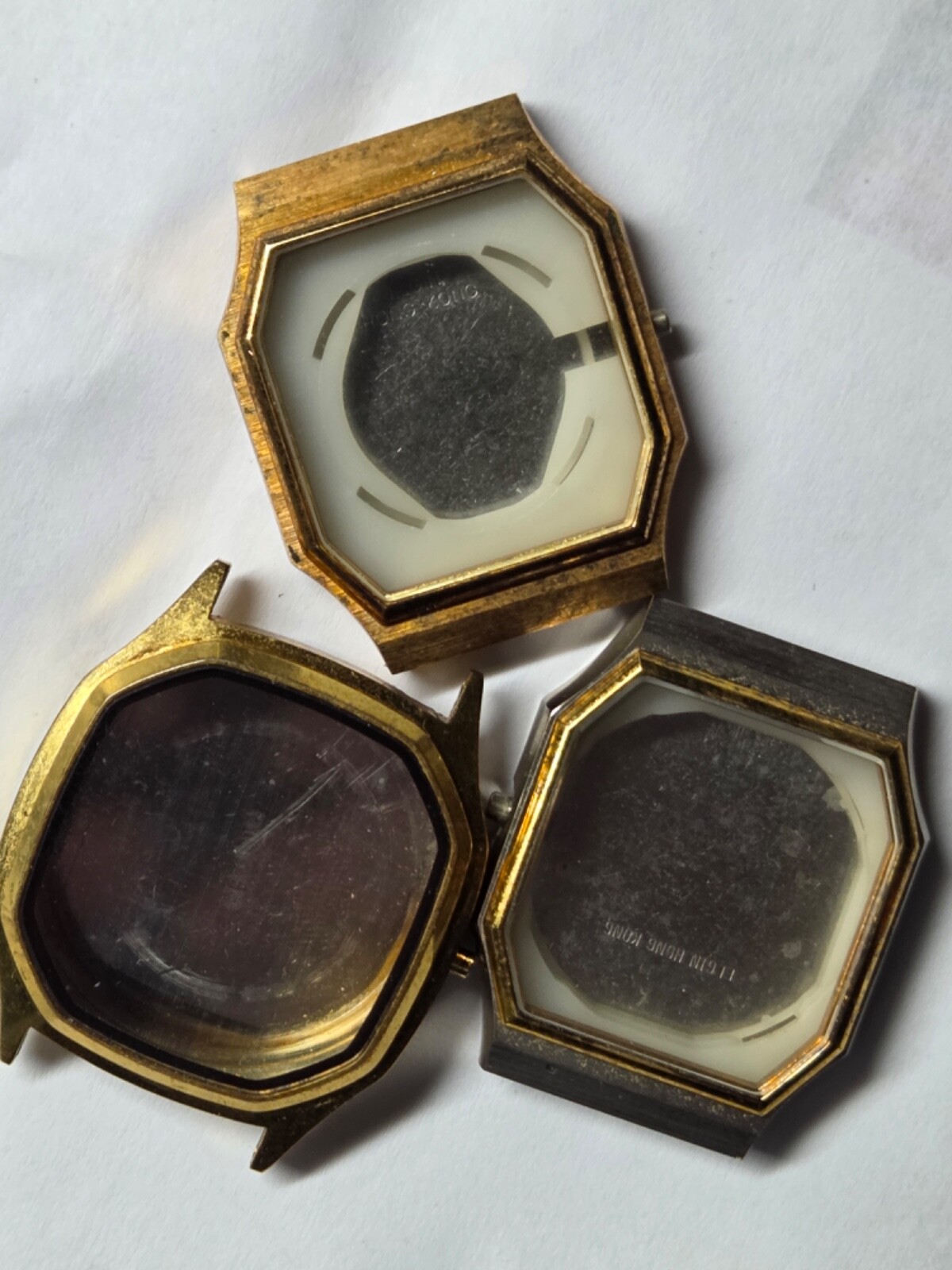 Four (4) men’s watch cases. 1980’s. For quartz movements. One has rotating bezel