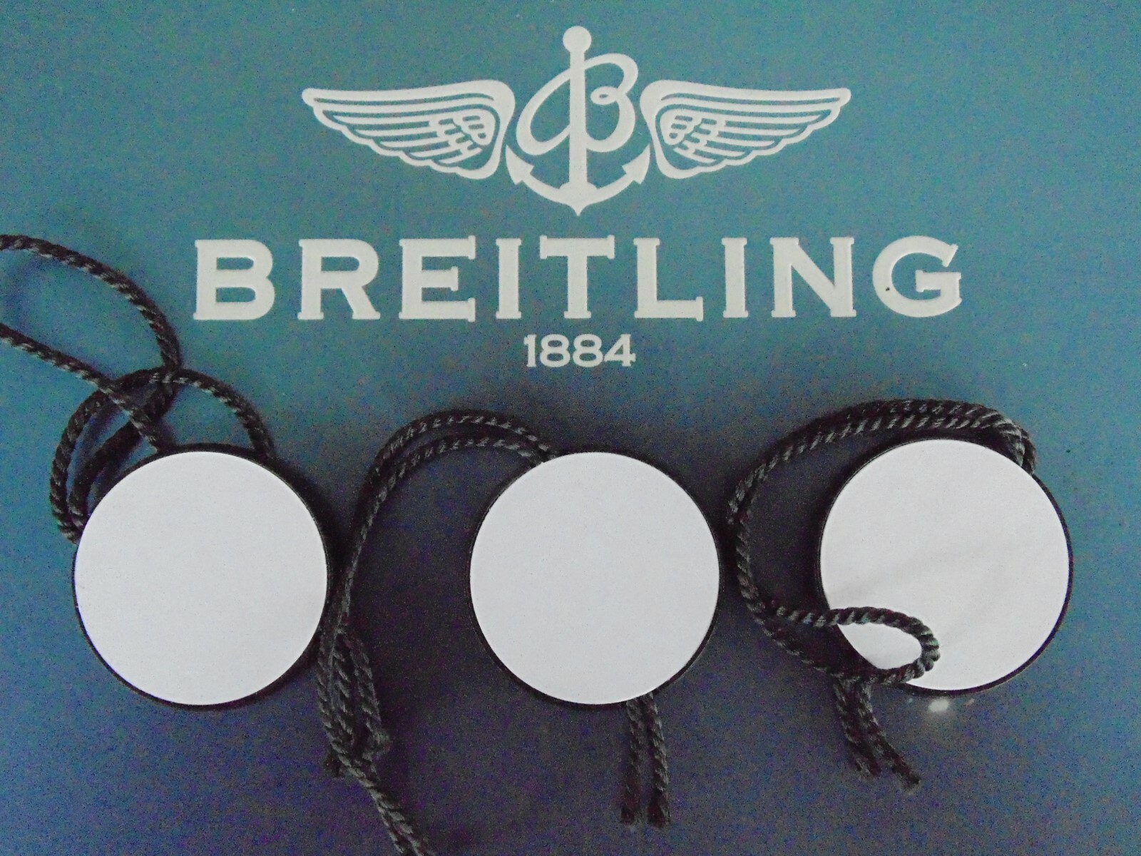 BREITLING FACTORY JEWELER’S BLACK PLASTIC WATCH HANG / SWING TAG THREE PIECE LOT