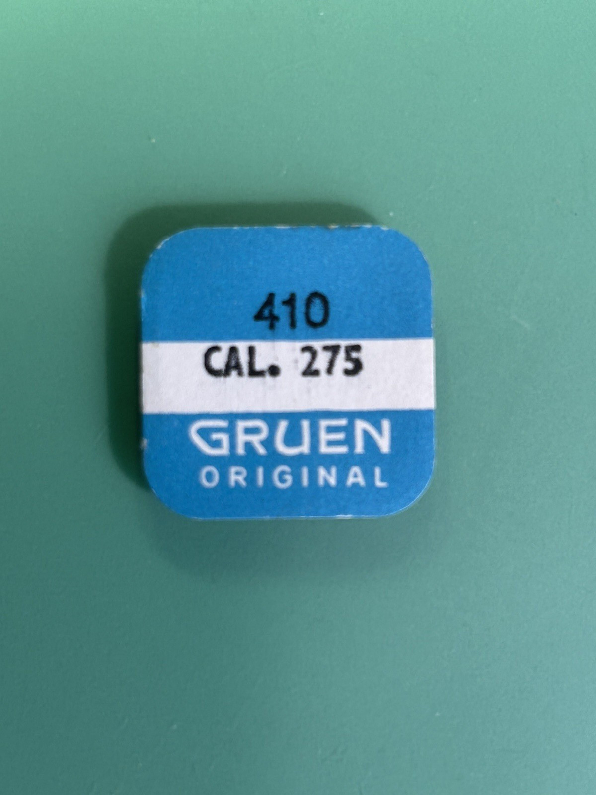 Gruen Cal. 275 – Winding Pinion 410 – New Old Stock – Orig. Part and Packaging